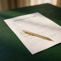A form page with a gold pen resting on it