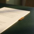 A printed reference sheet with an amber index tab on a dark green desk
